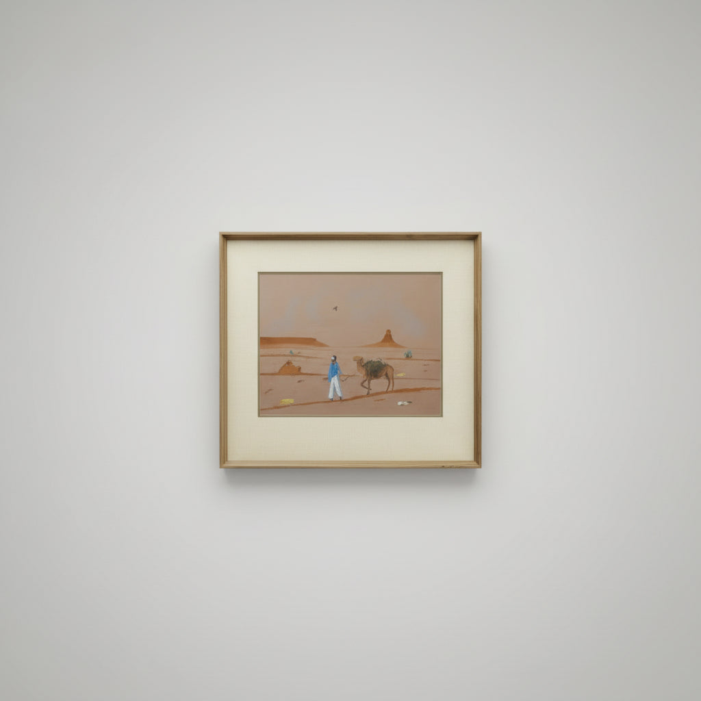 Framed artwork of a desert scene with a person and camel.