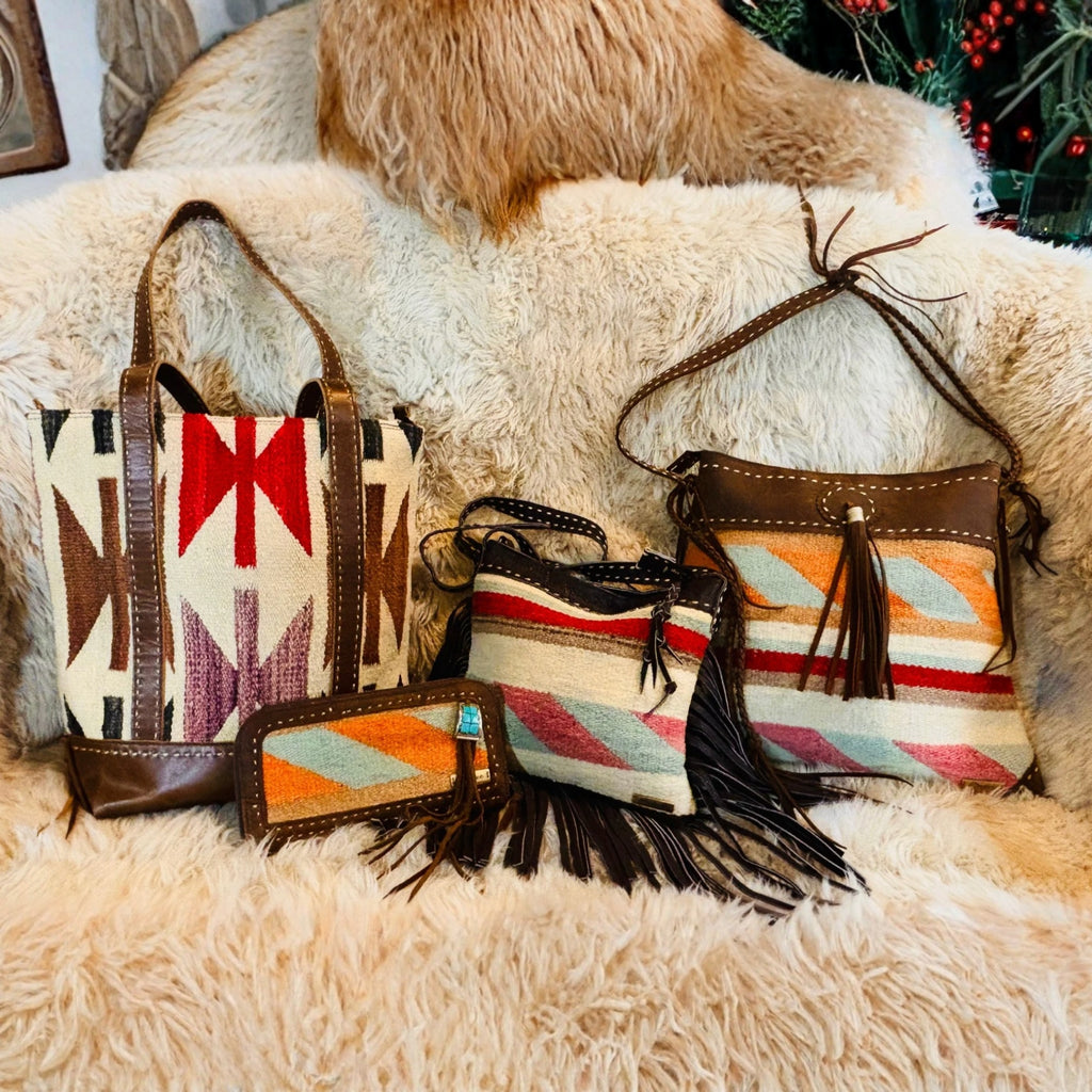 Three handbags with geometric patterns and fringes on a textured surface