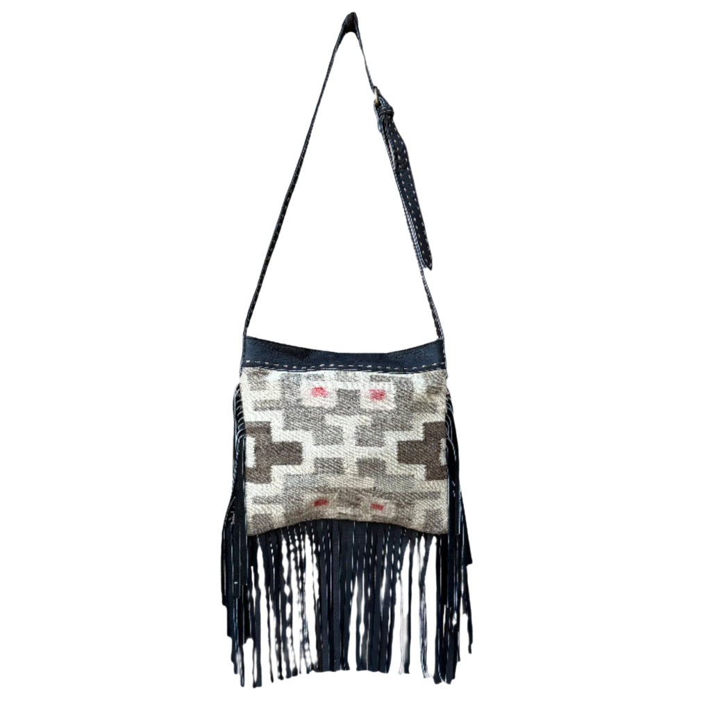 Handbag with geometric pattern and black fringe on a white background
