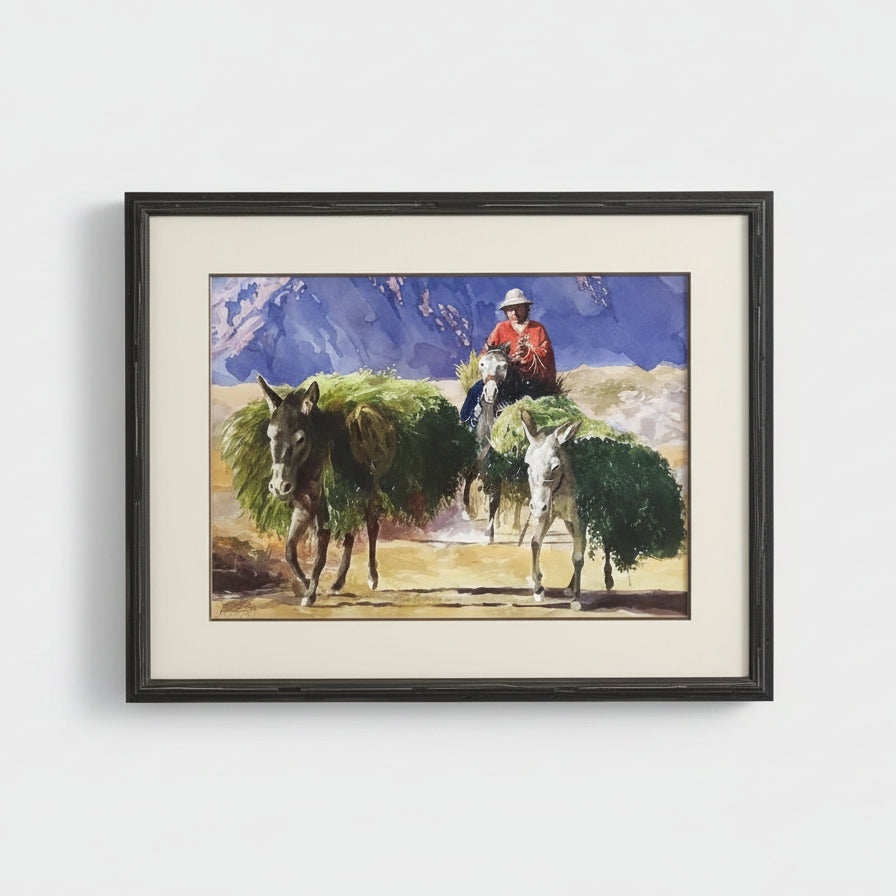 Framed artwork of a person on horseback with two donkeys carrying a load.