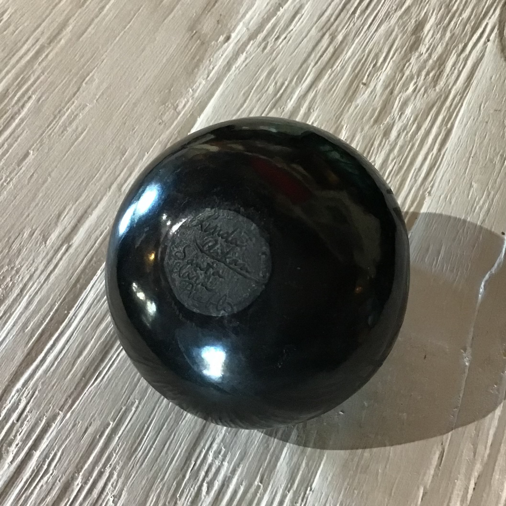 Black spherical object on a textured light-colored surface