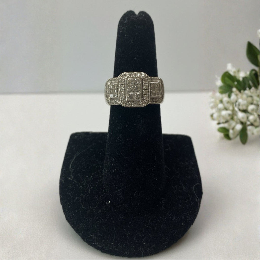 Silver ring on a black jewelry stand with a white background