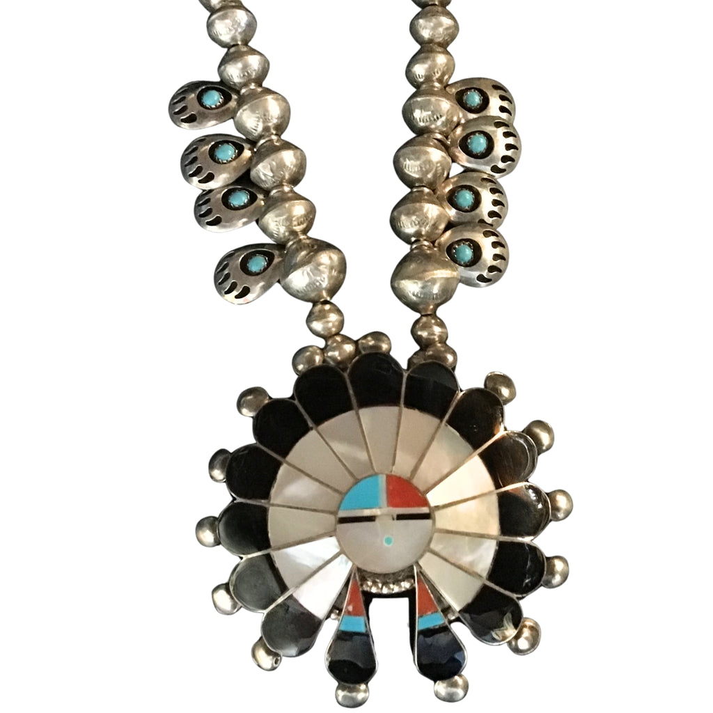 Necklace with a large, intricate pendant featuring black, white, red, and blue colors on a white background.
