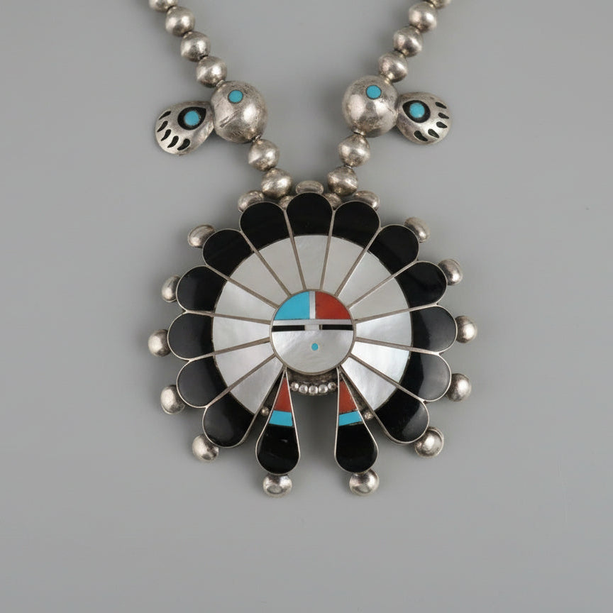 Native American style necklace with a large pendant on a gray background